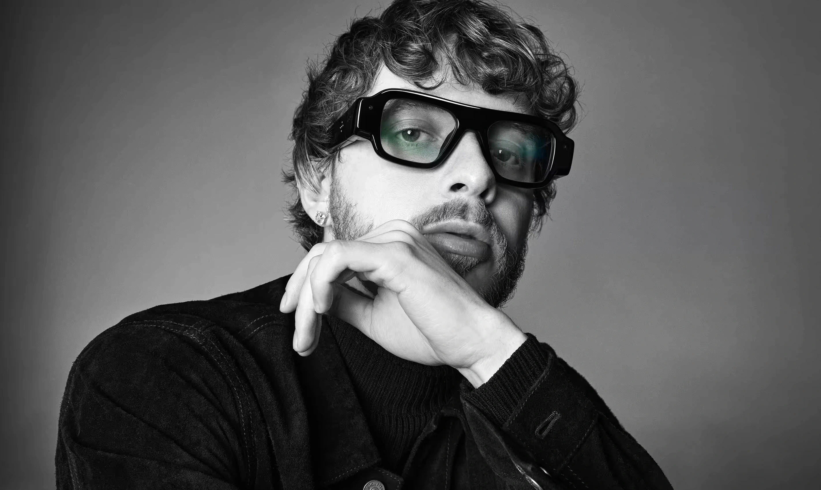 Man wearing black Snap SPECS AR glasses with see-through waveguide lenses, black and white portrait.