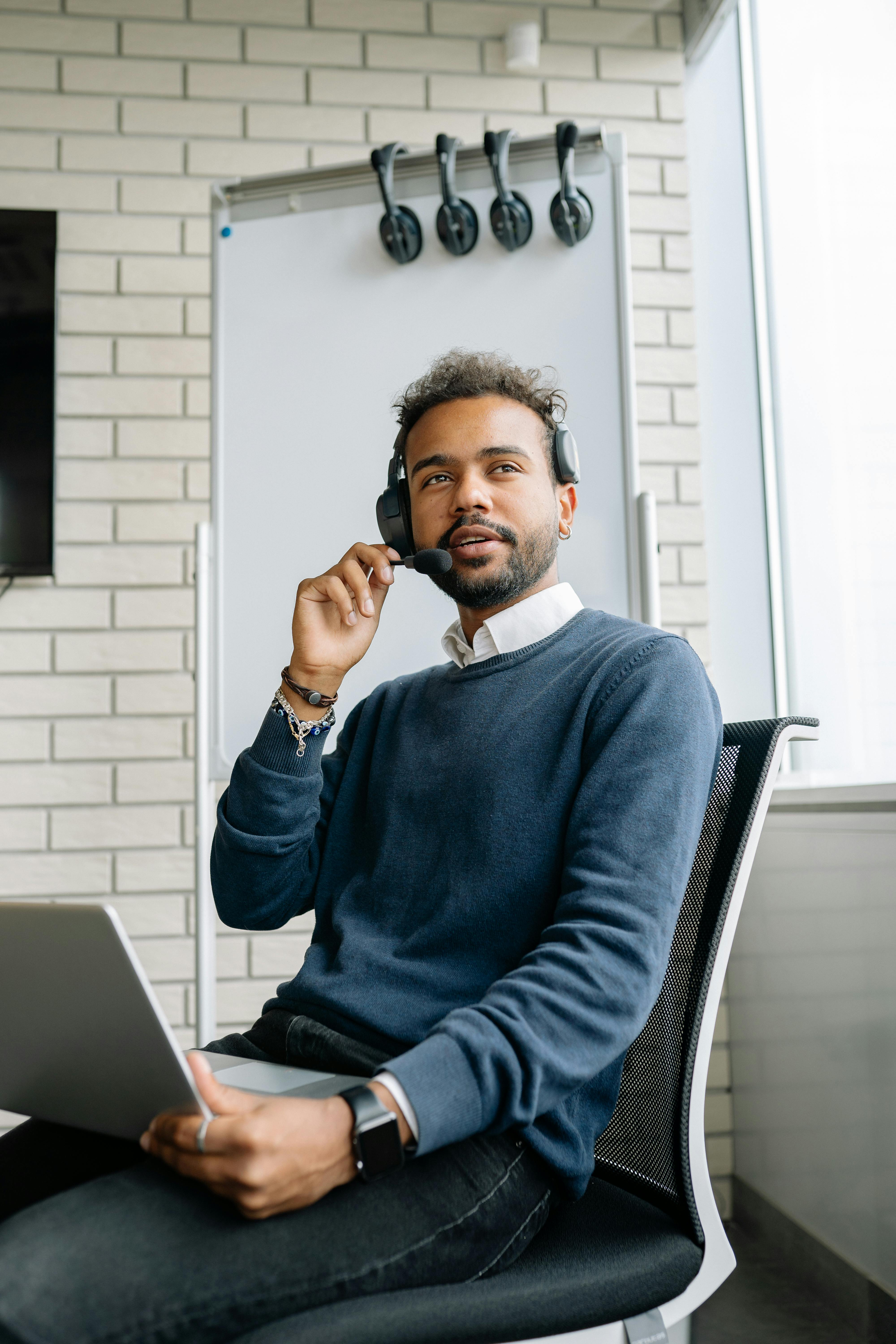 a man sitting at a desk talking on a phone