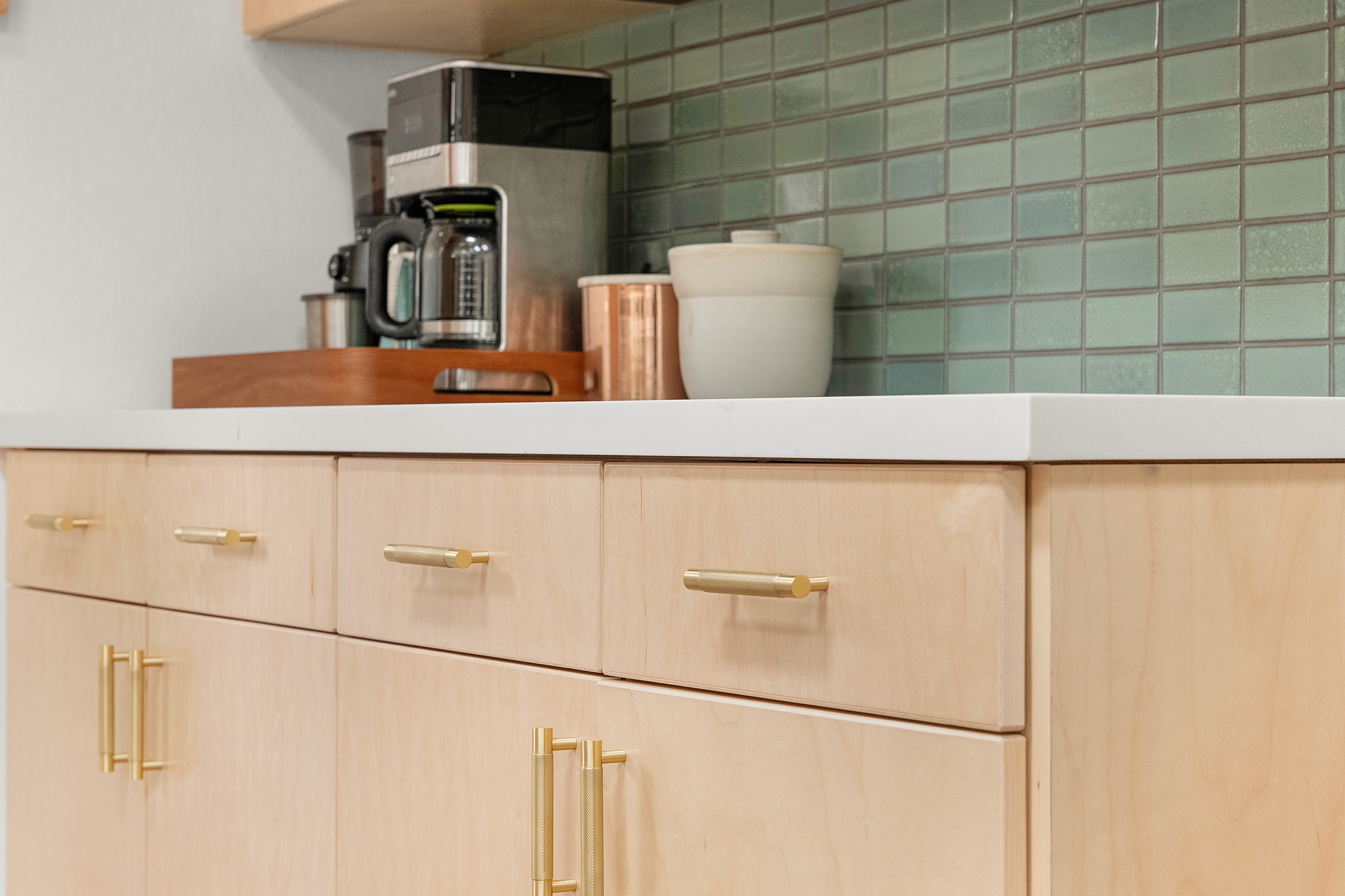 “Gray kitchen remodel with quartz island, stainless steel appliances, and patterned tile backsplash”
