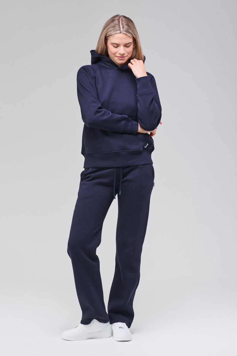 Model wearing navy classic hoodie, hand holding collar