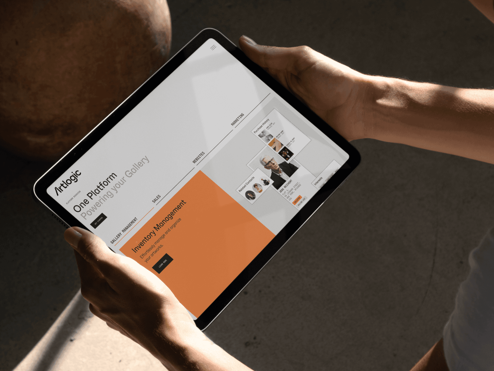 A person holding a tablet displaying a digital interface with graphs and information in a well-lit environment.