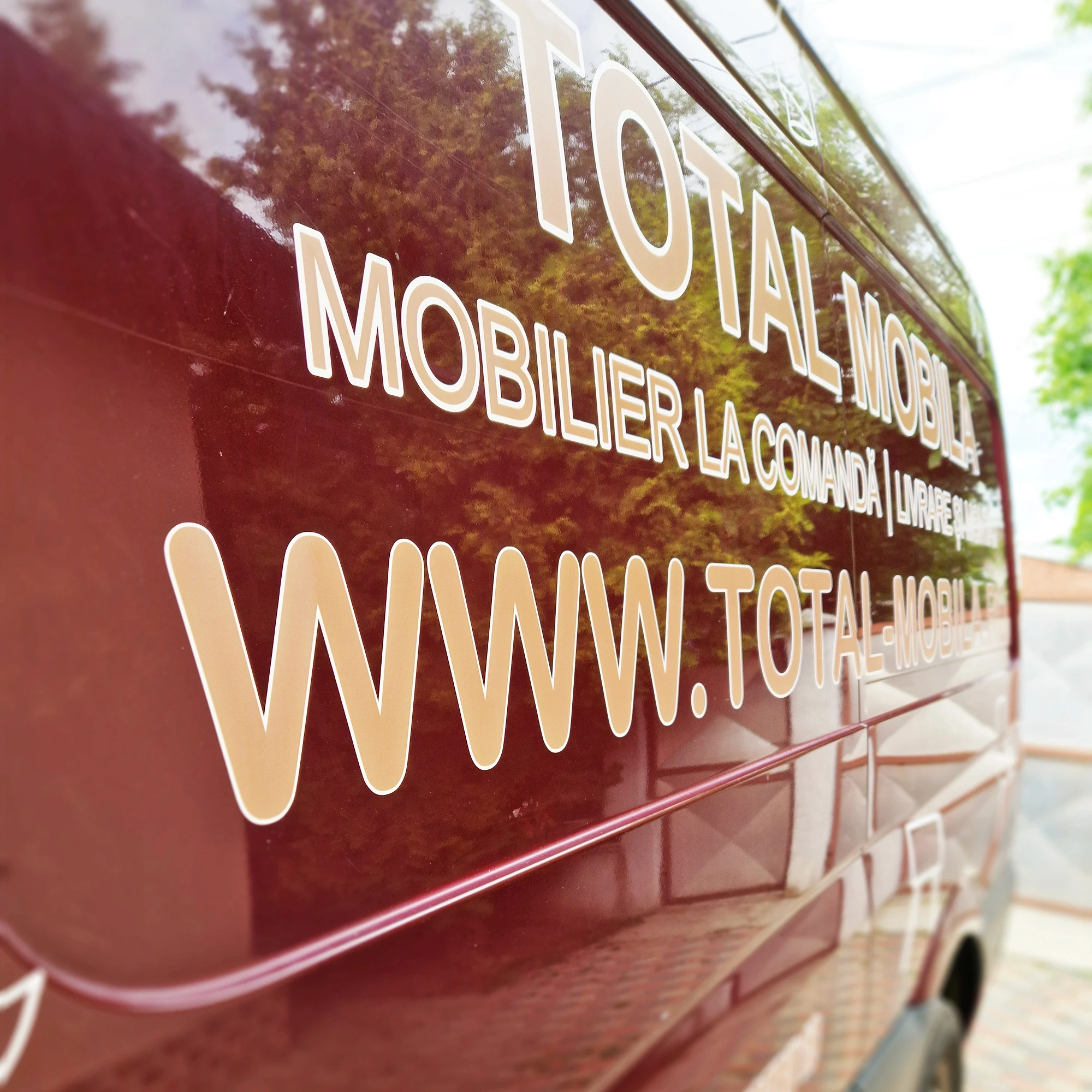 Detaliu colantare dubă Total Mobilă, text și logo aplicate pe folie
