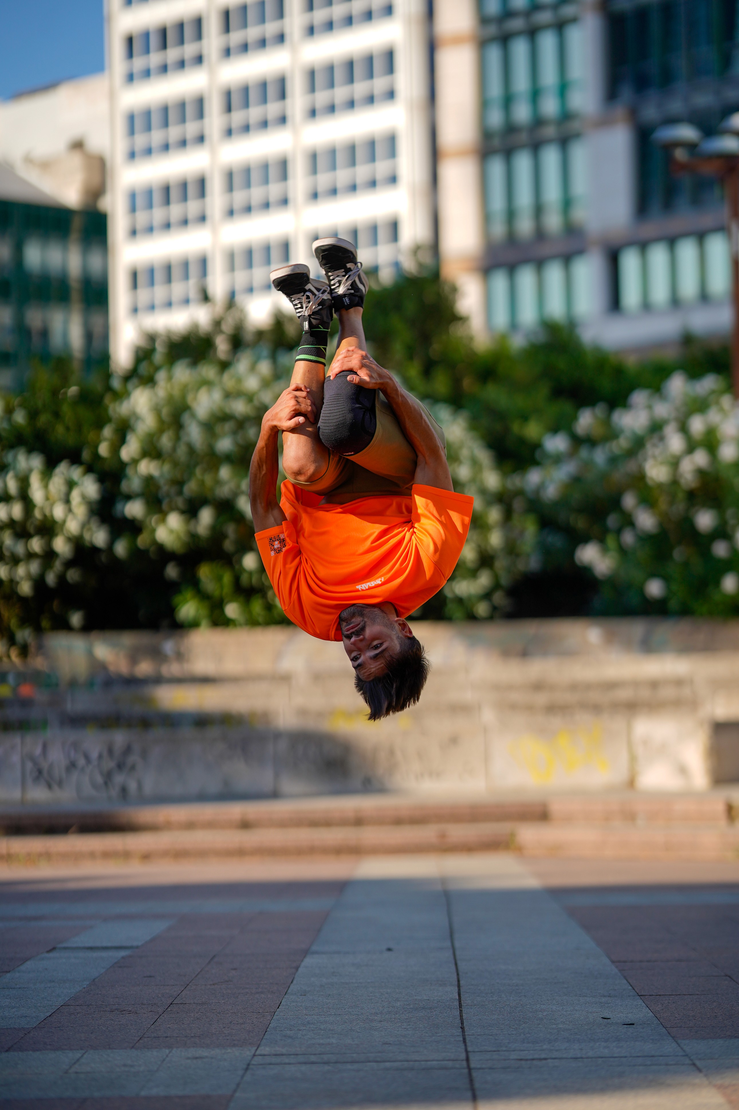 alteta professionista di parkour e insegnante che fa un sideflip con magli aurban heroes