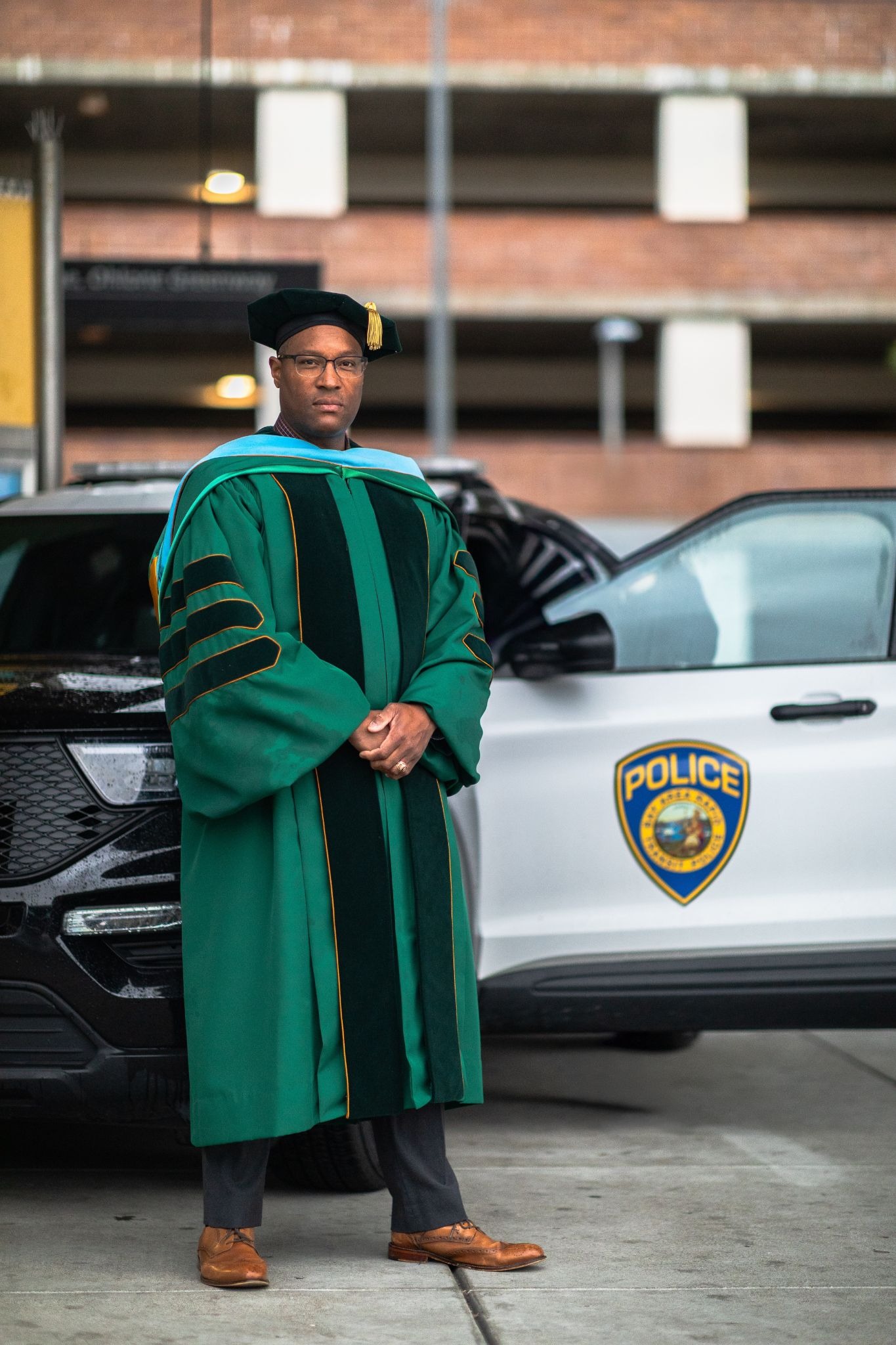 Dr. Quincy K. Ruffin wearing a dark suit and glasses with his arms crossed.