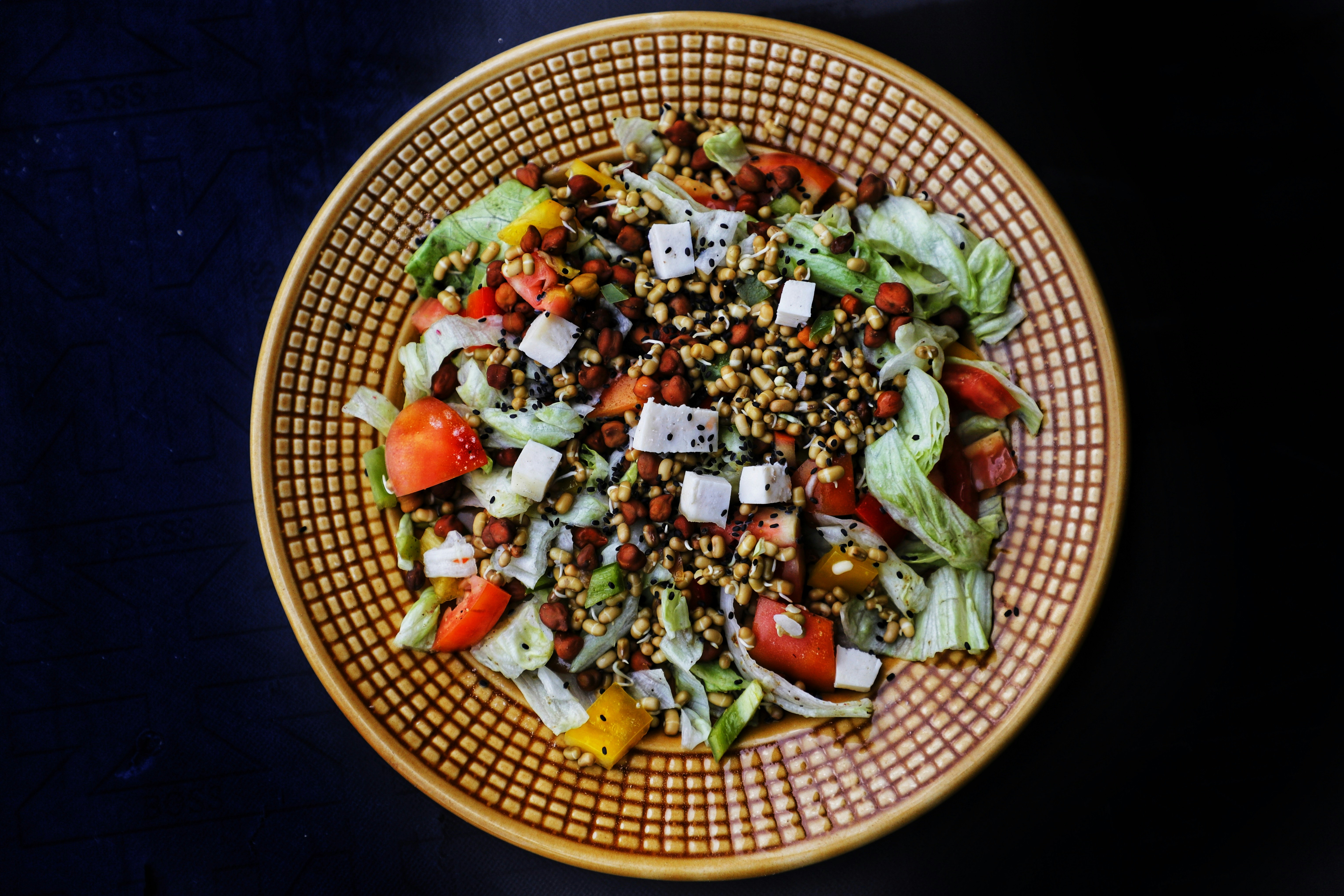 a bowl of salad with lettuce, tomatoes, cucumbers, and
