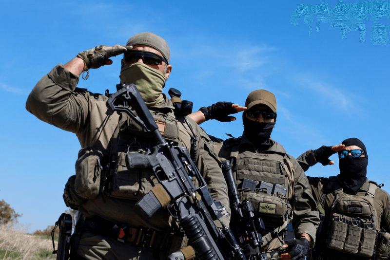 group of men in red and black uniform walking on snow covered road during daytime