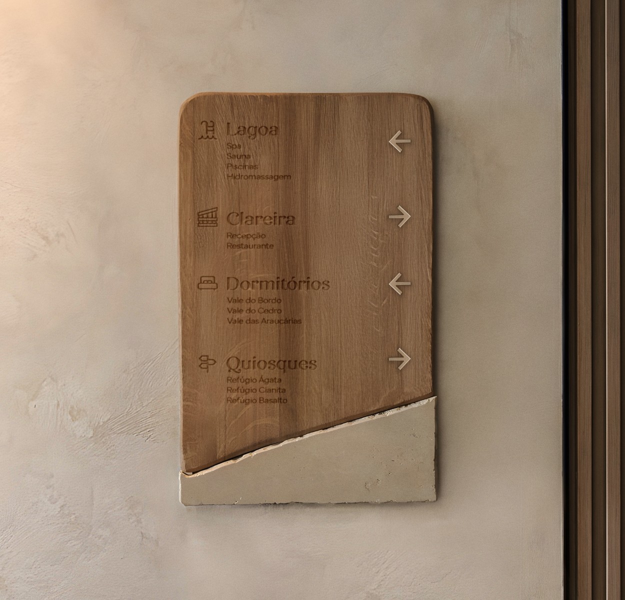 Painel de madeira com nomes dos espaços do hotel fixado na parede.