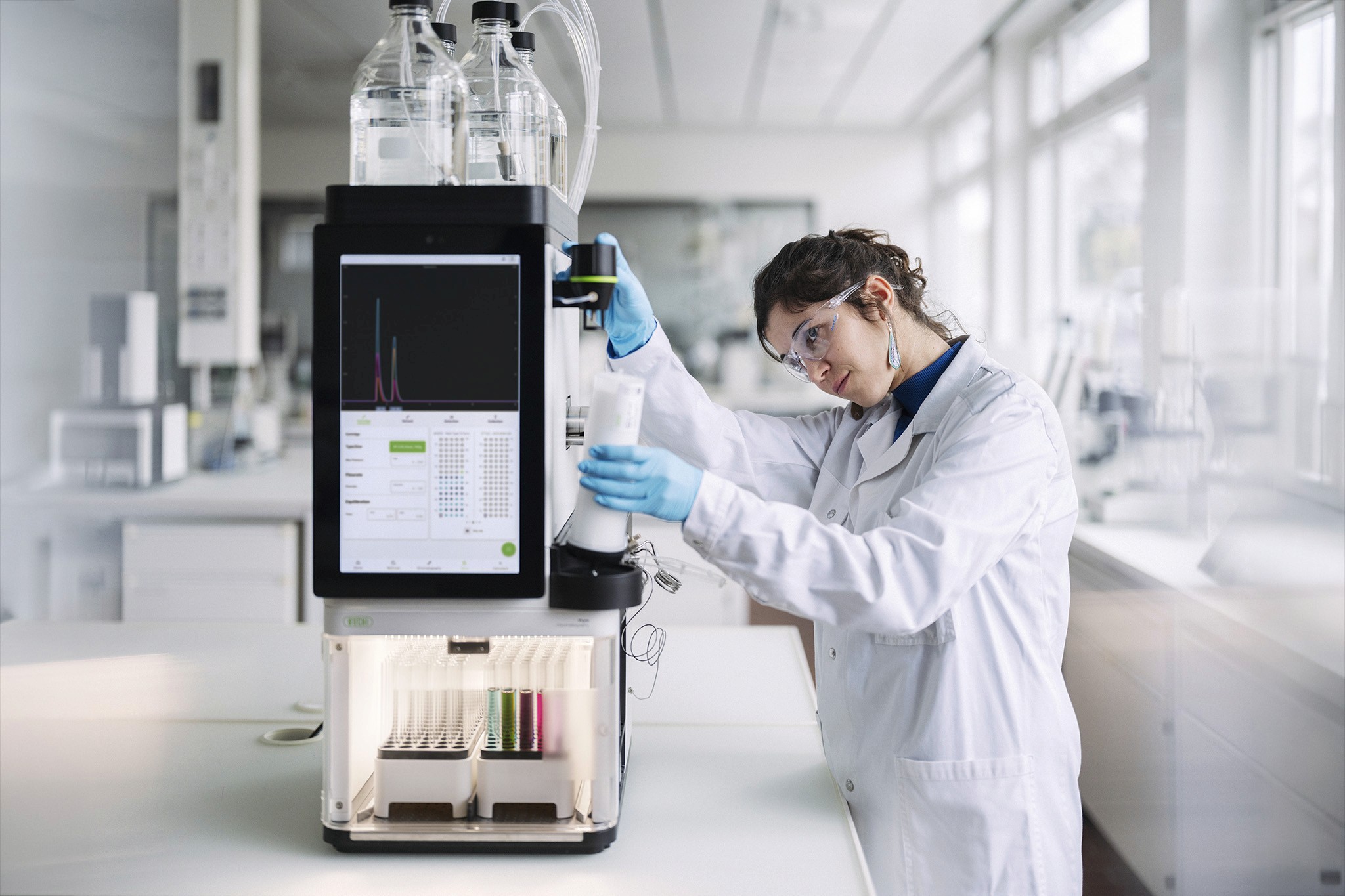 Frontansicht von Flüssig-Chromatografiegerät Pure Excellence Line in Labor mit Person, die eine Kartusche einsetzt (Büchi, 2026)