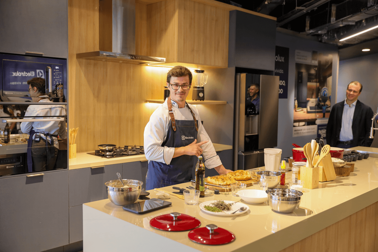 Smart speaker with glowing top next to a phone, set against a green background