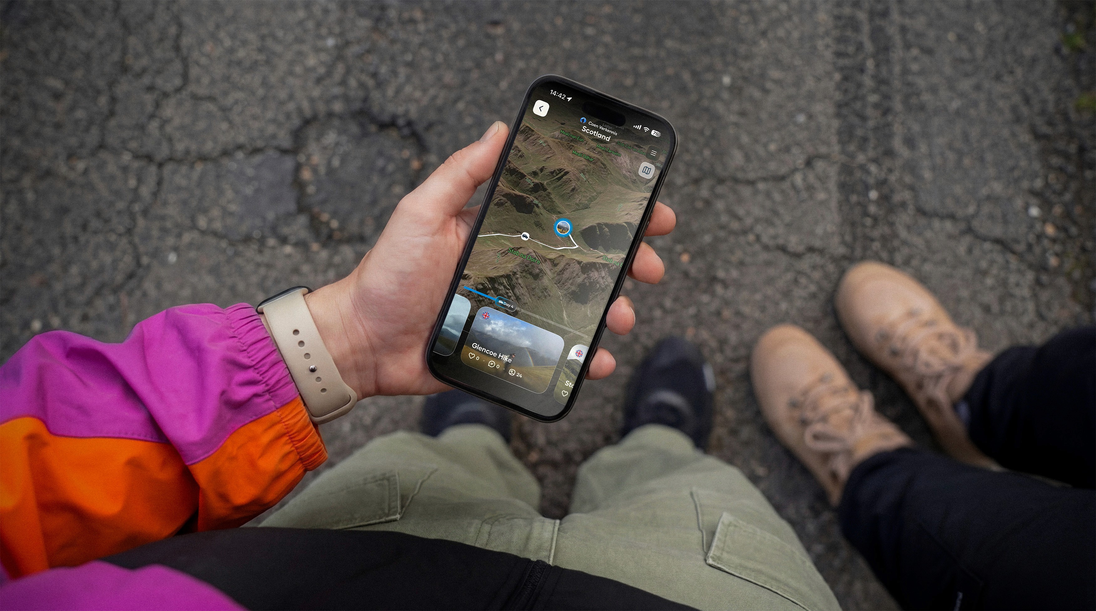 A hand holding a phone showing route terrain with Polarsteps Plus.