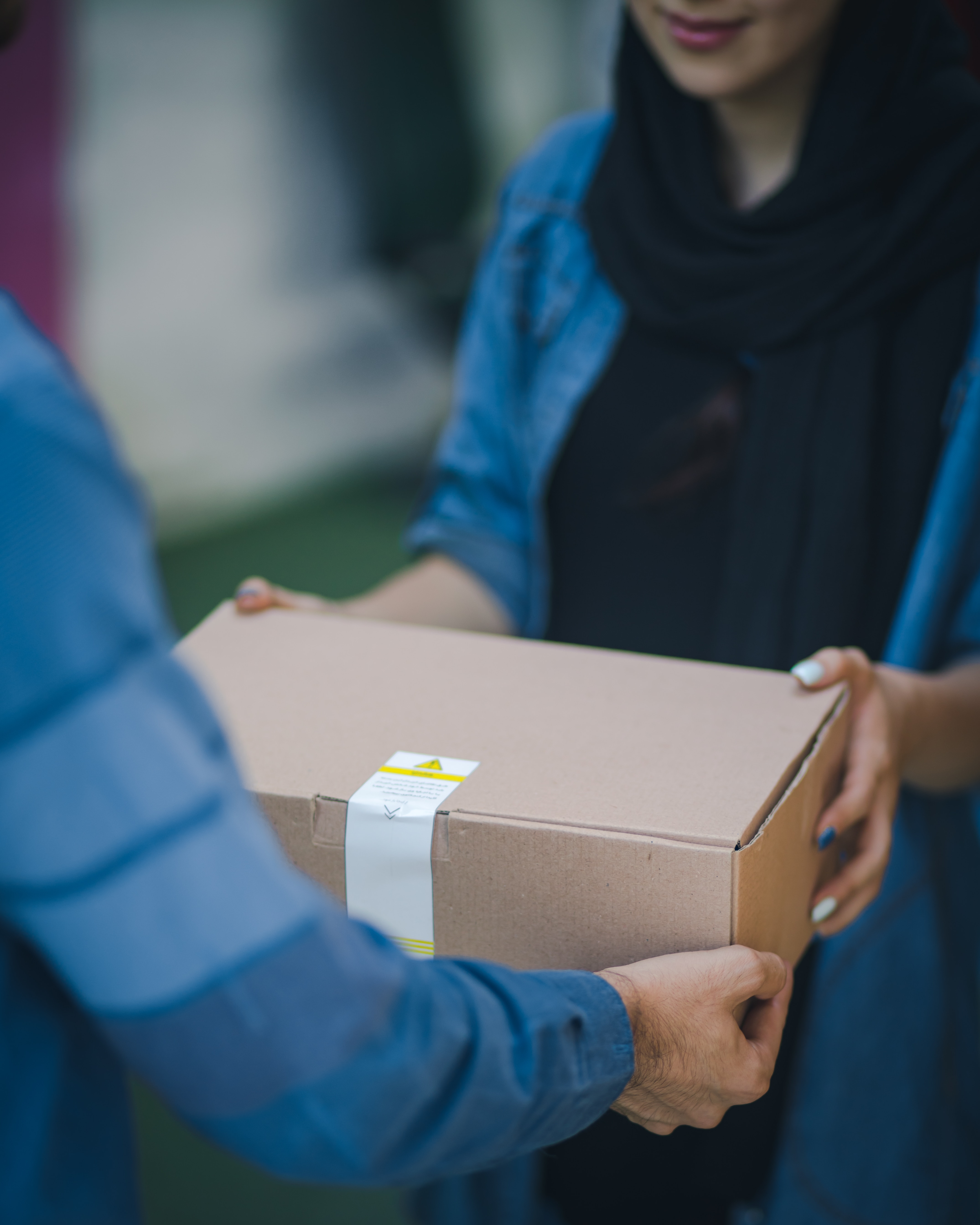 Delivery person hands package to customer.