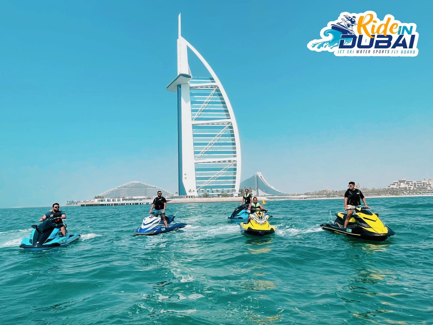 Riders enjoy a jet ski tour near Dubai Marina with the Burj Al Arab in the background.