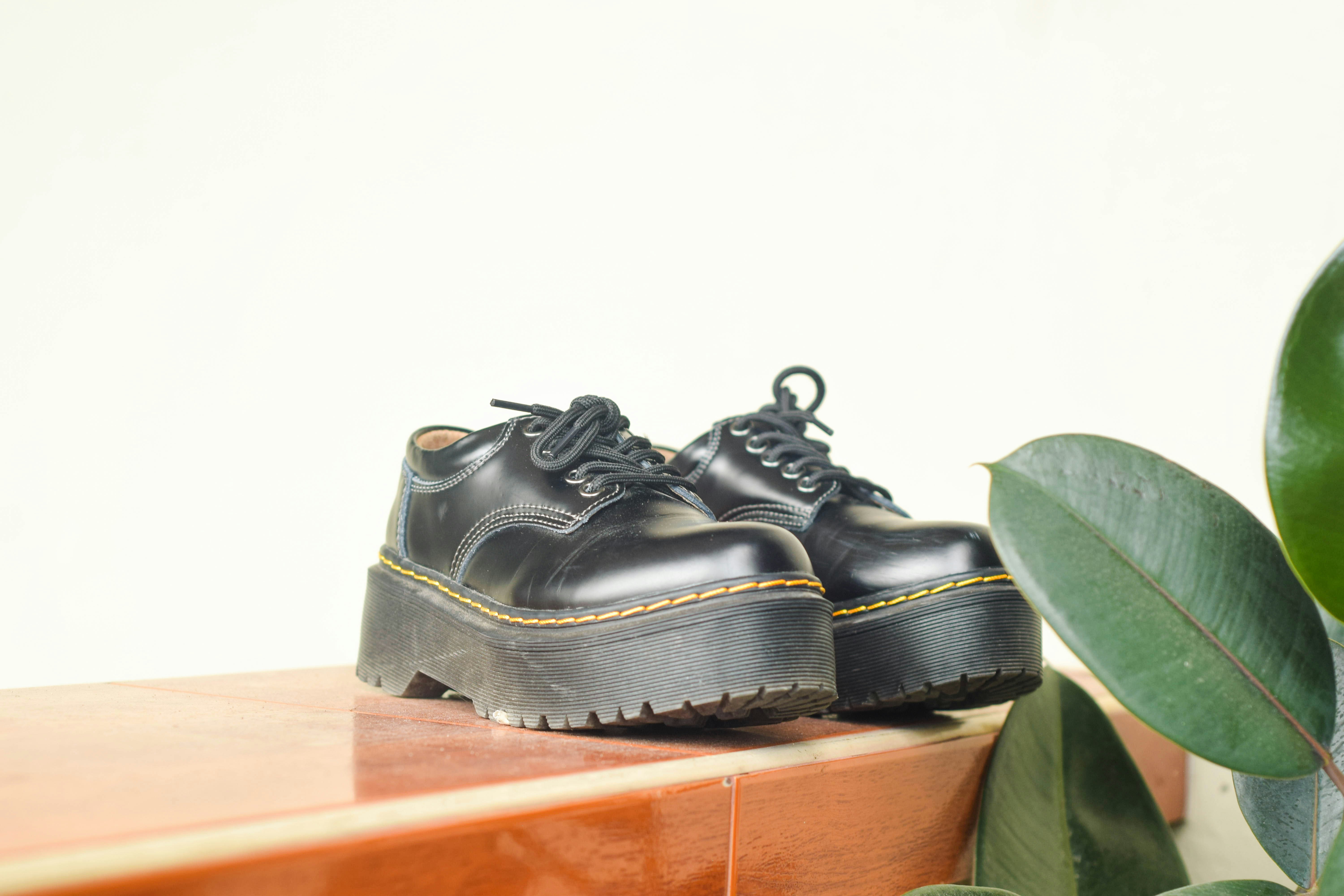 A pair of black shoes sitting on top of a wooden table