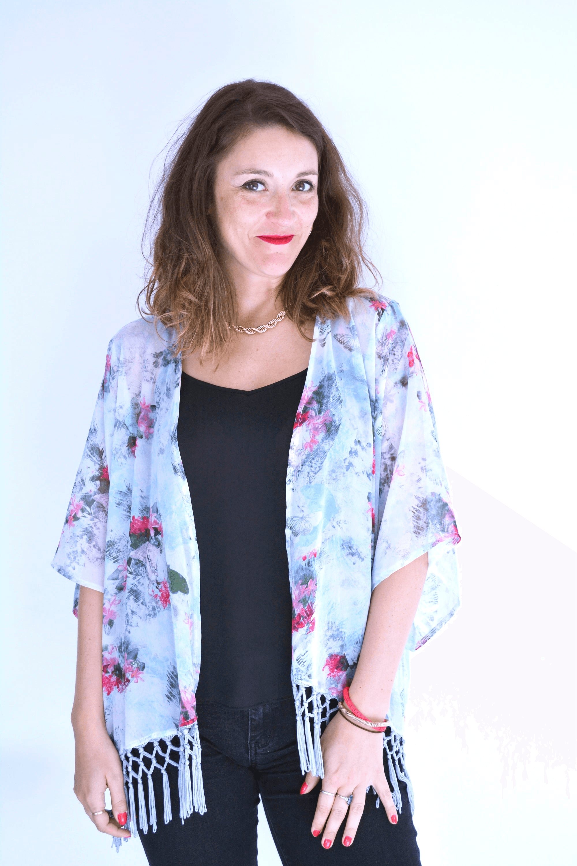 A person in a patterned outfit with closed eyes posing.