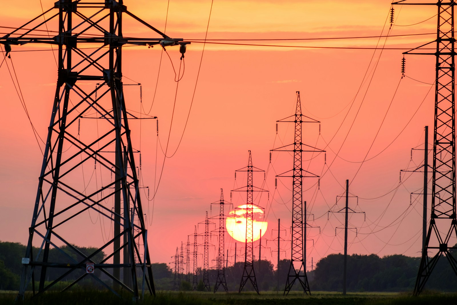 Silhouetted power lines at sunset over Kansas plains