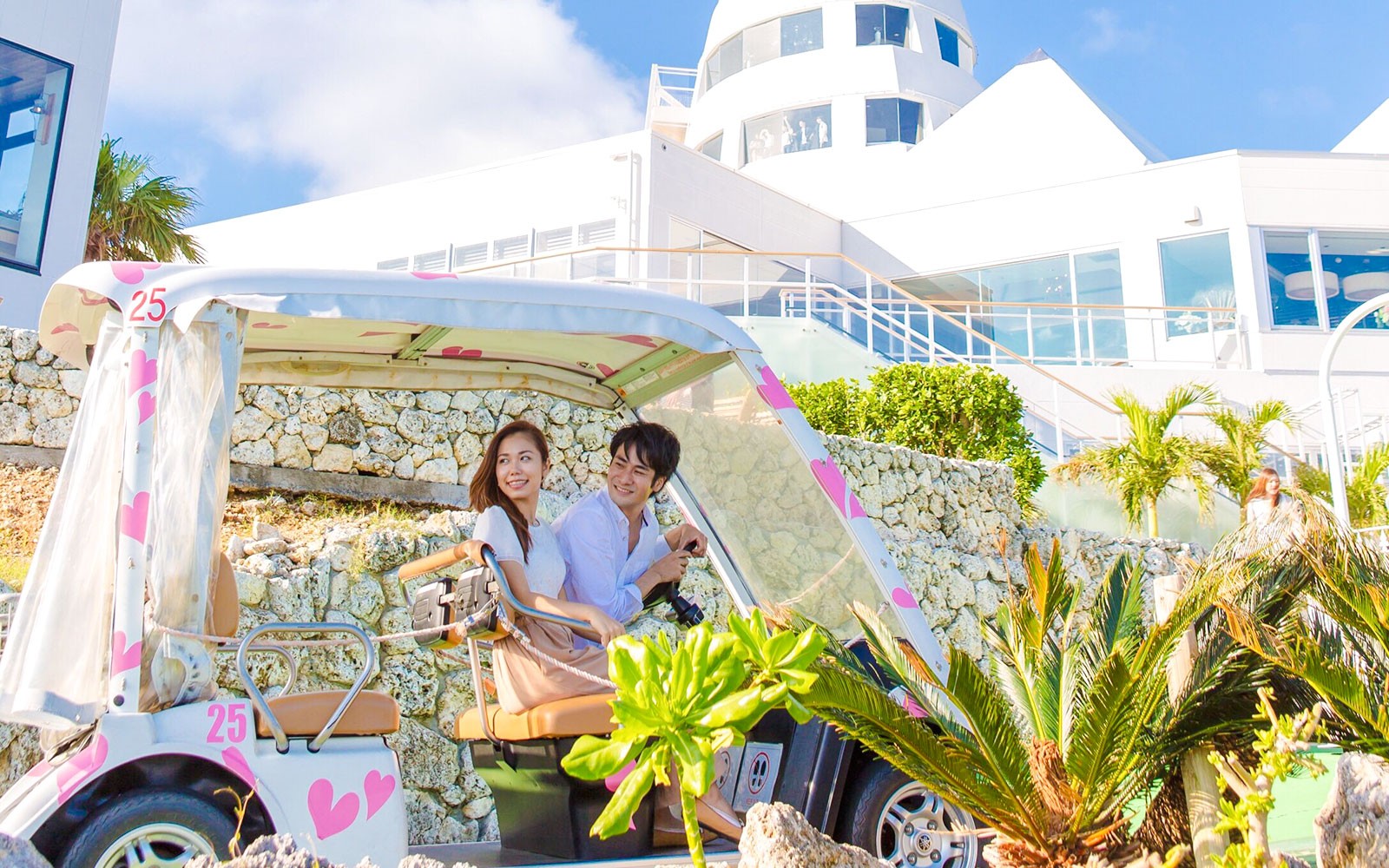 Ζευγάρι οδηγεί διακοσμημένο γκολφ καροτσάκι προς το σύγχρονο ξενοδοχείο στο Hakone Kowakien Yunessun.