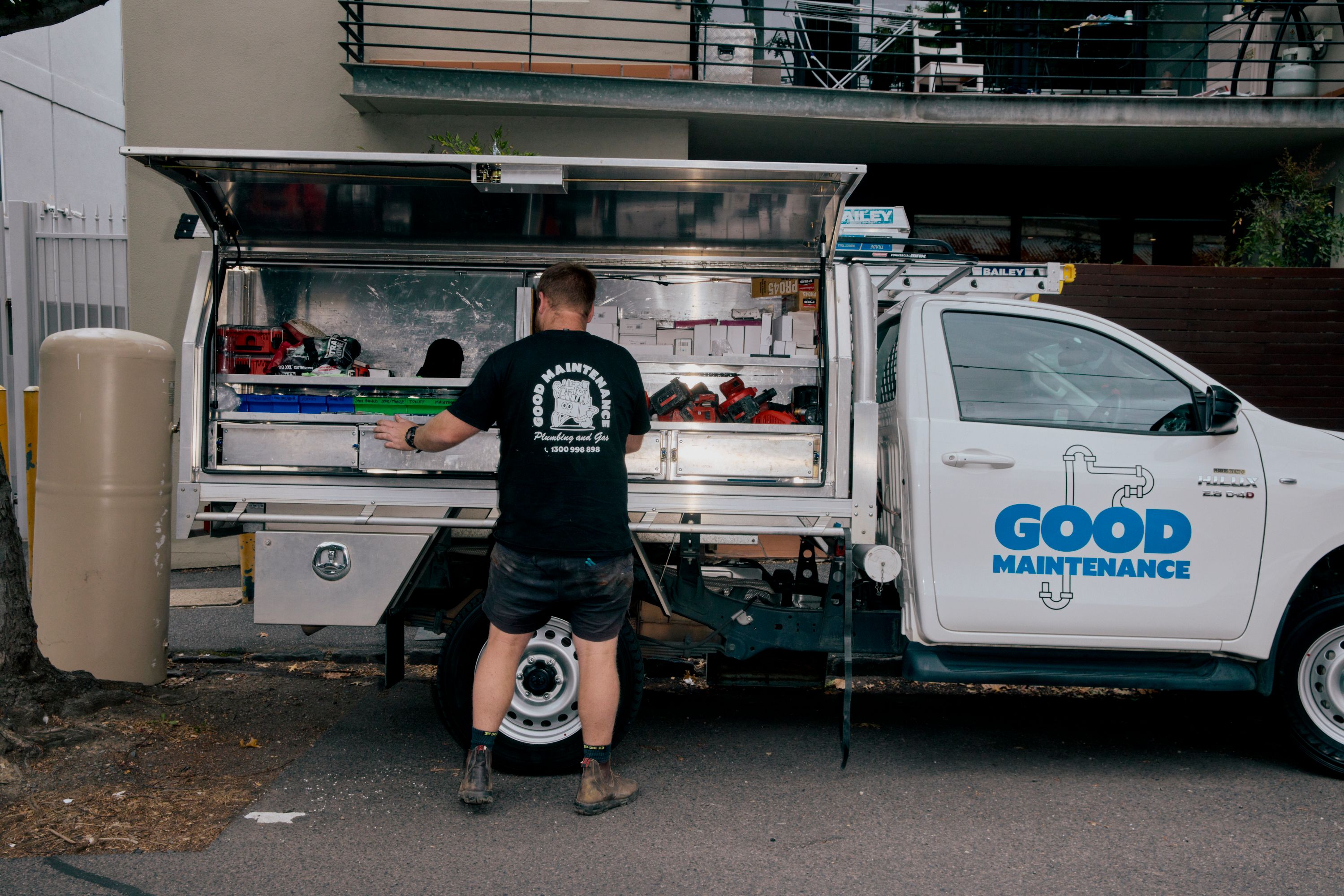 Good Maintenance Plumber collecting tools for a job from the back of a company van