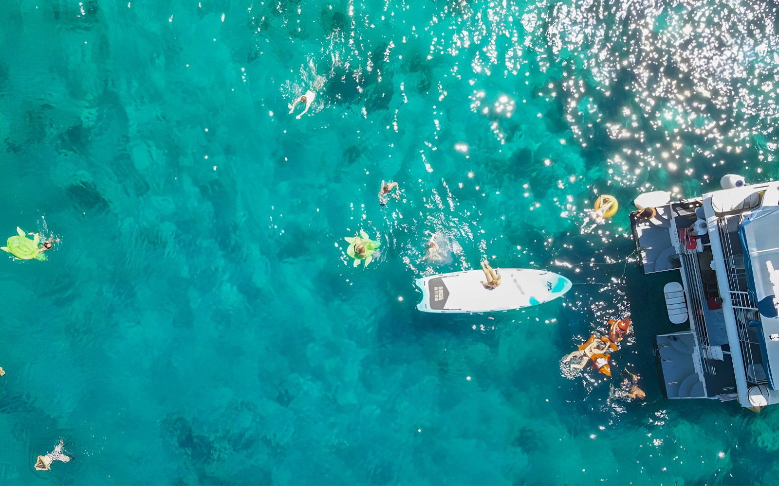 People swimming near a boat in clear blue waters during Split: Hvar & 3 islands cruise.