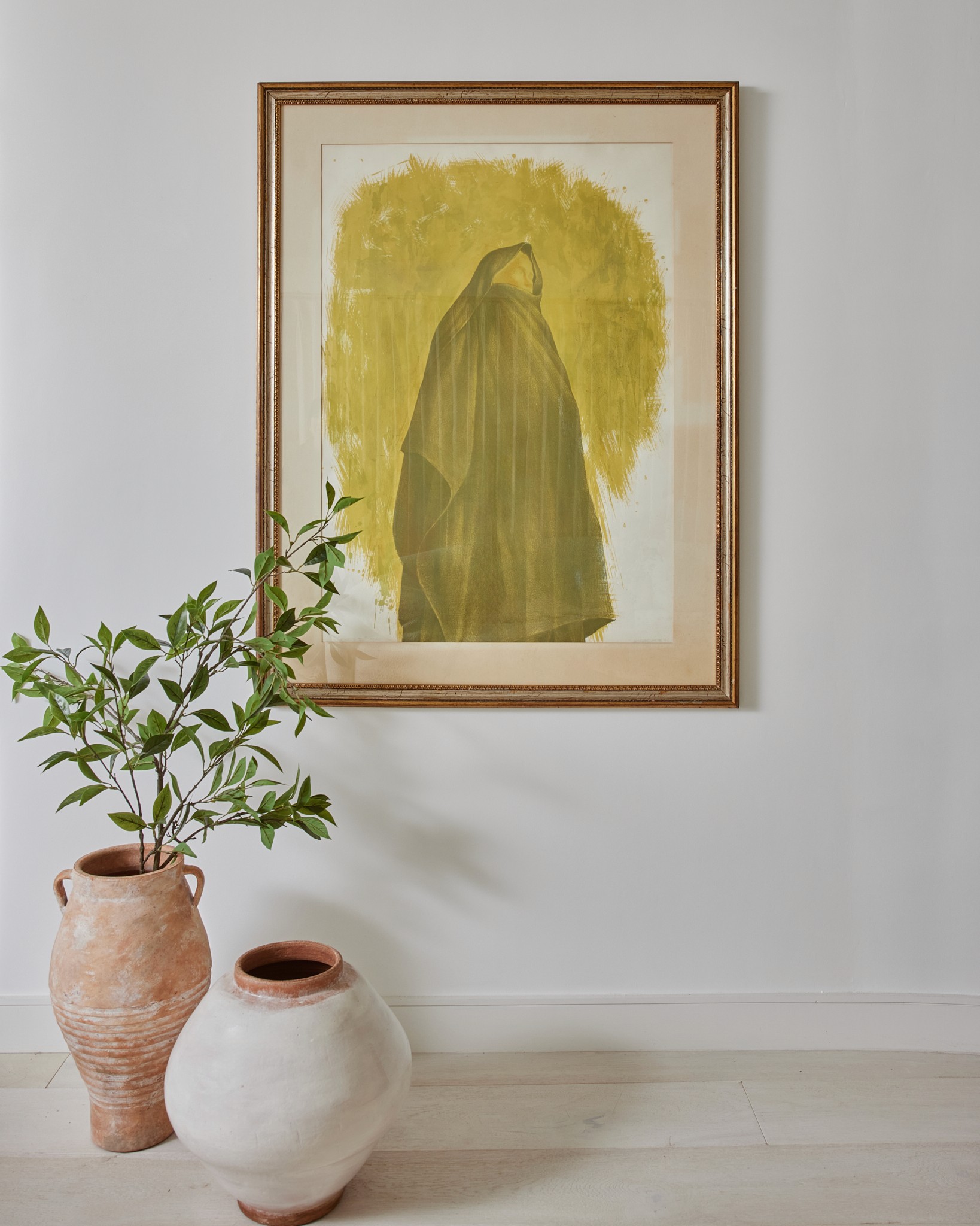 Vignette of living room art wall with framed green watercolor piece and two terracotta pots  by Jubilee Interiors in Los Angeles, California