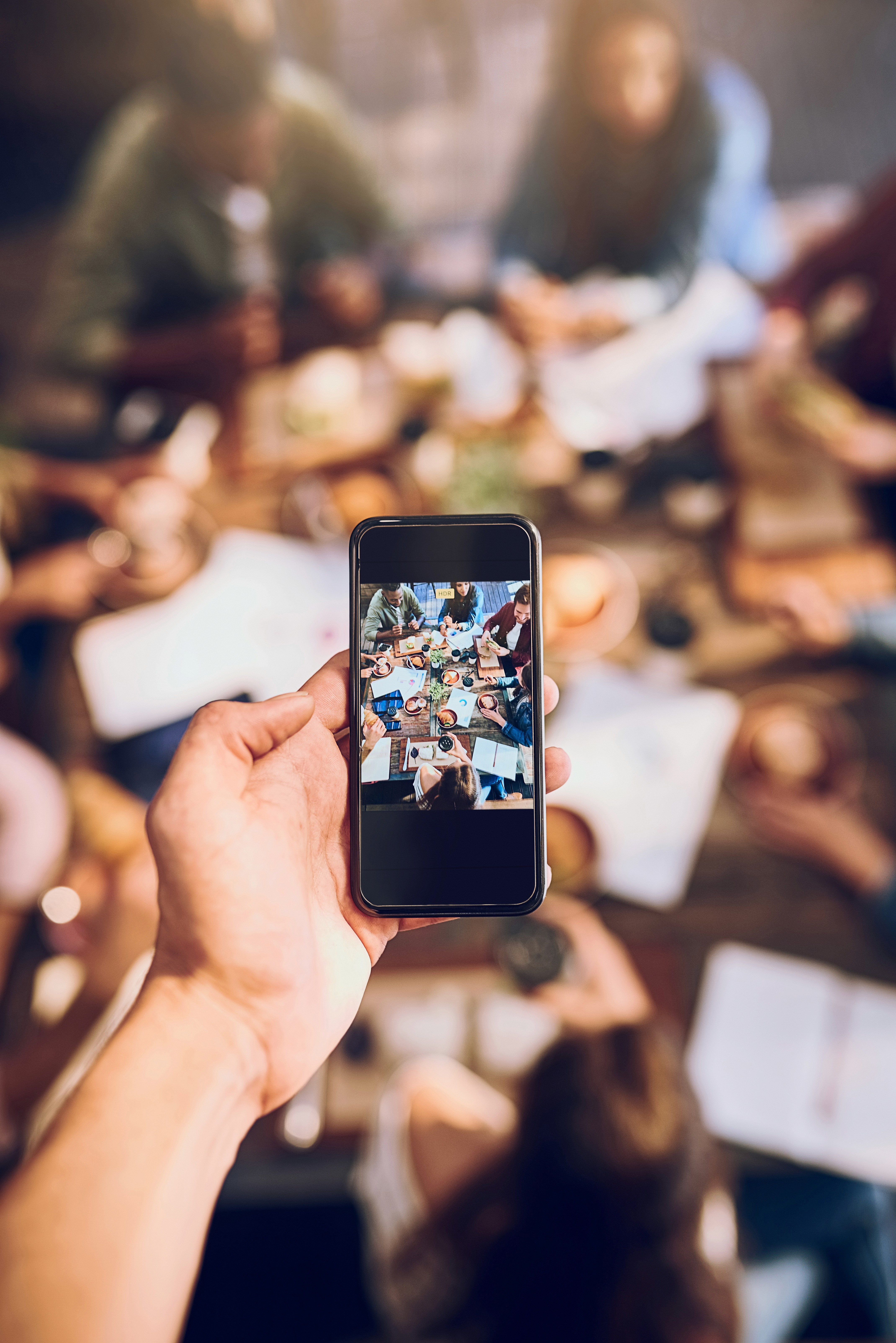 Cropped shot of a man taking a photo on a smartphone representing user-generated content created by real people to boost brand engagement. 