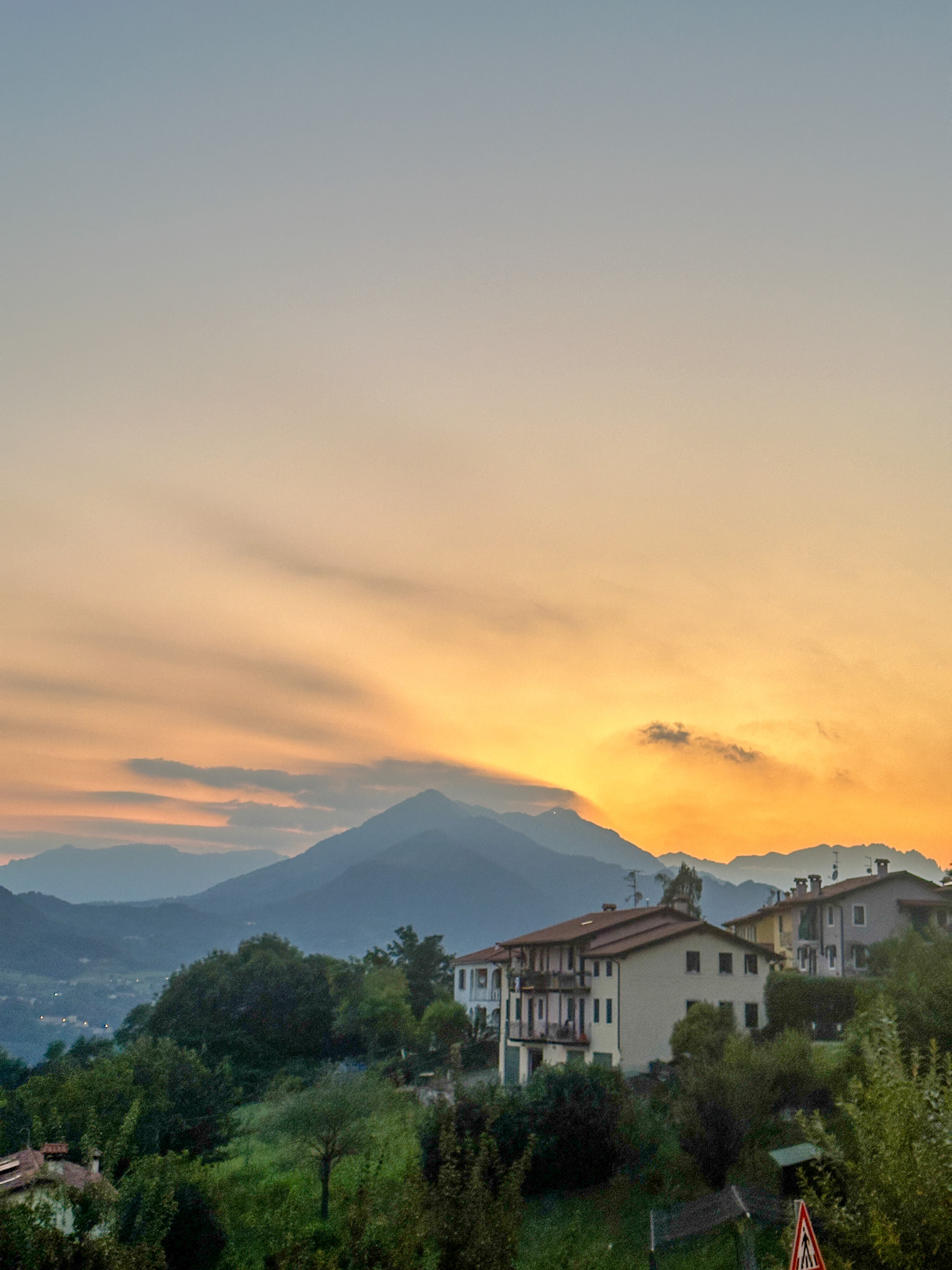 Snow-capped mountains illuminated by twilight, reflecting in calm waters below, creating a serene winter scene.