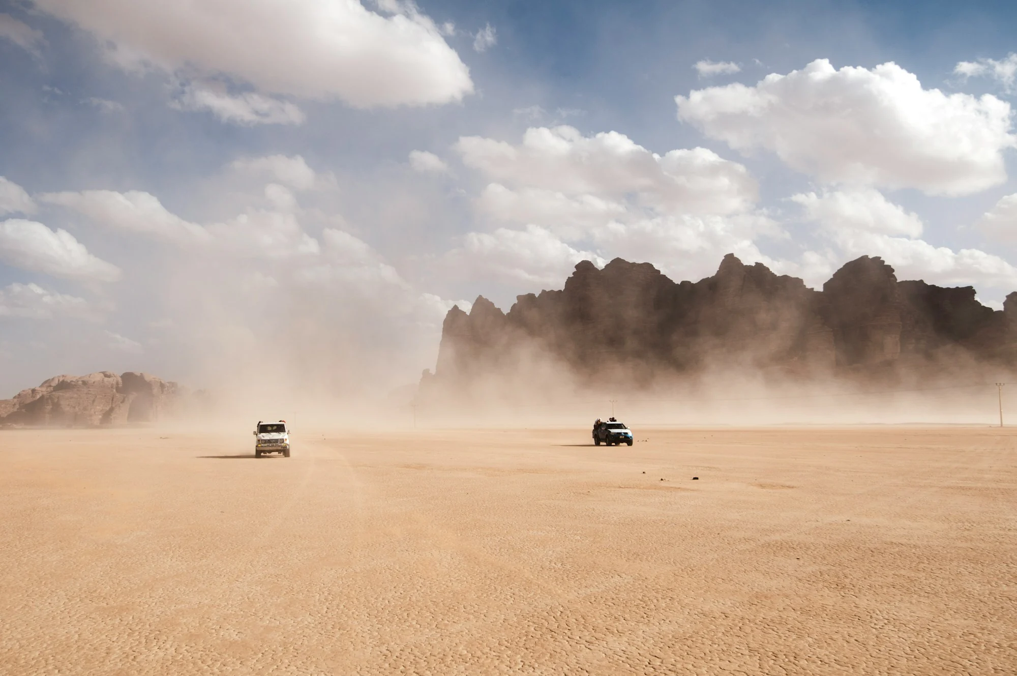 Rally vehicles crossing a dusty desert plain, the setting of the Paris-Dakar Rally the Cartier Cheich was created for