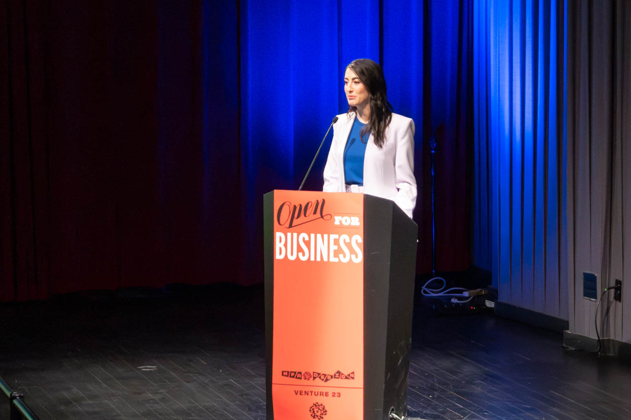 woman standing at a podium delivering a presentation