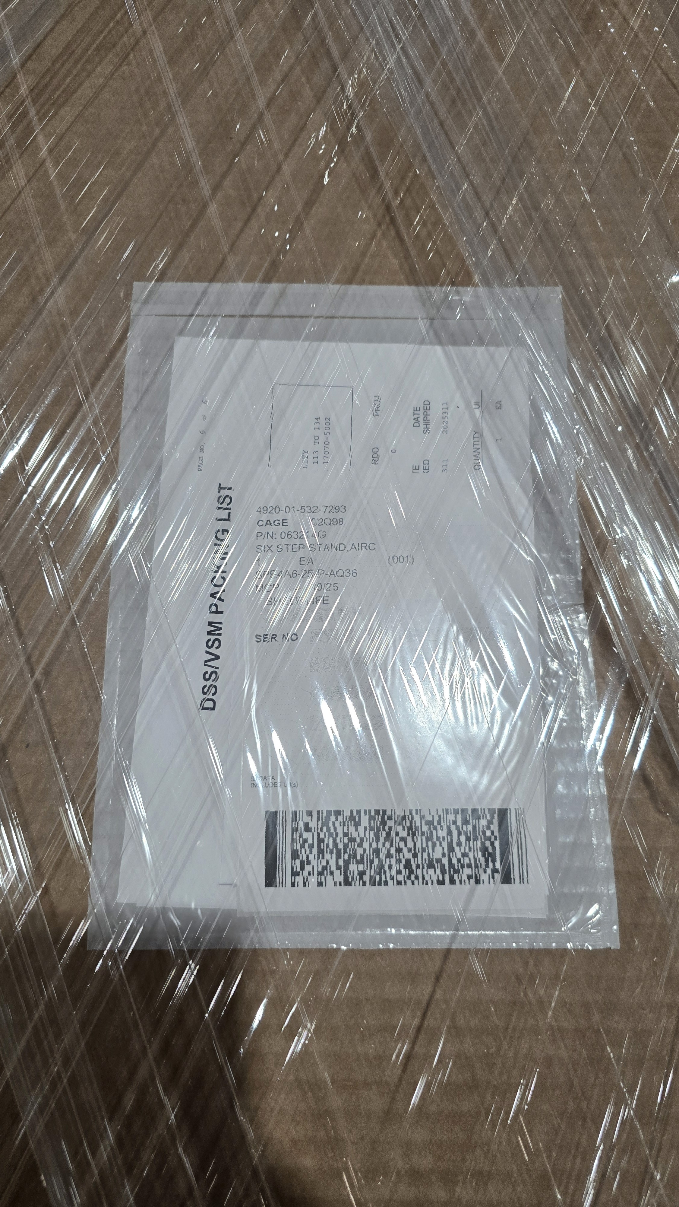 Close-up of a dark green leaf showing its textured surface and central vein against a muted background.