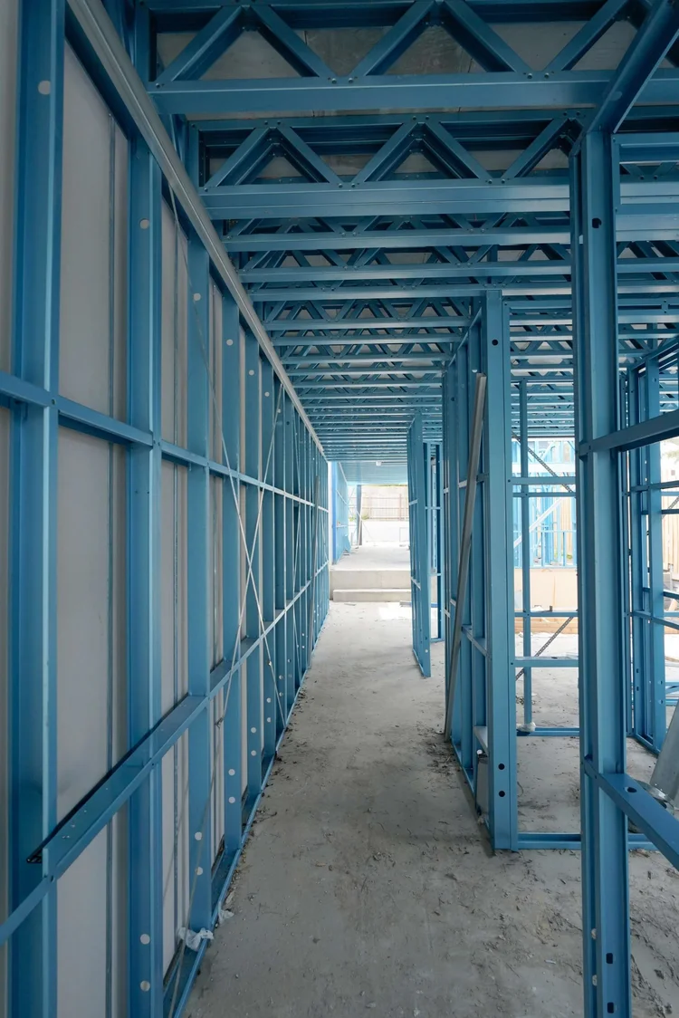 Steel frame structure in building construction site corridor.