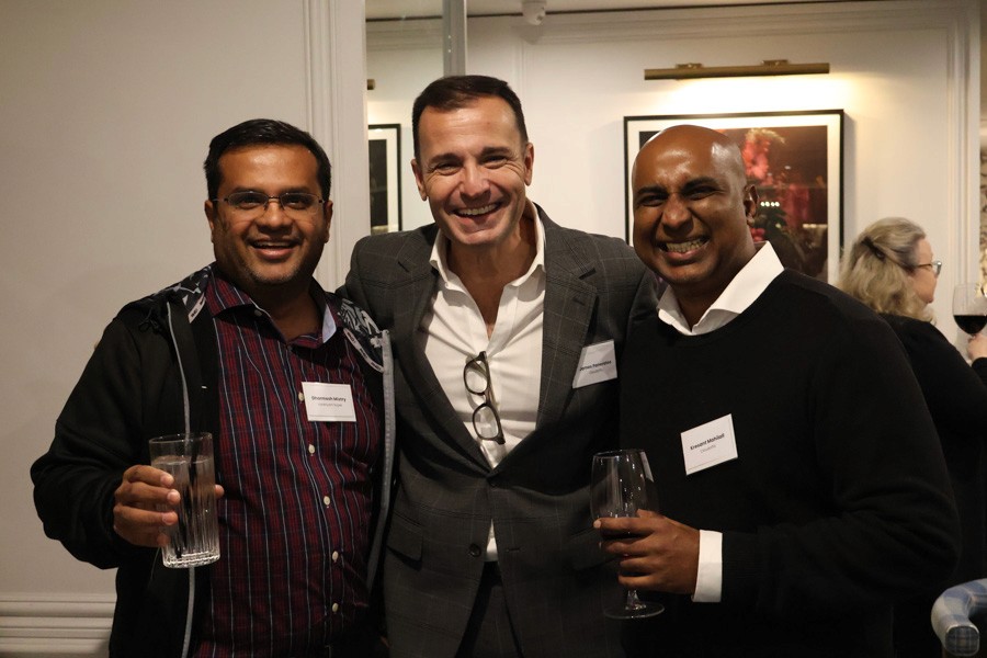 three men smile side by side