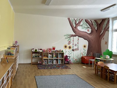 Herna s kobercem a malbou stromu na zdi