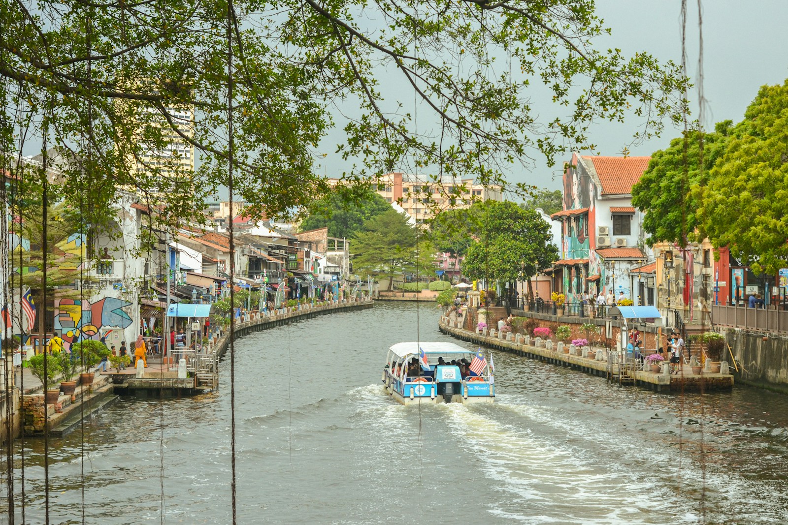 Boats along the Melaka River lined with heritage shophouses