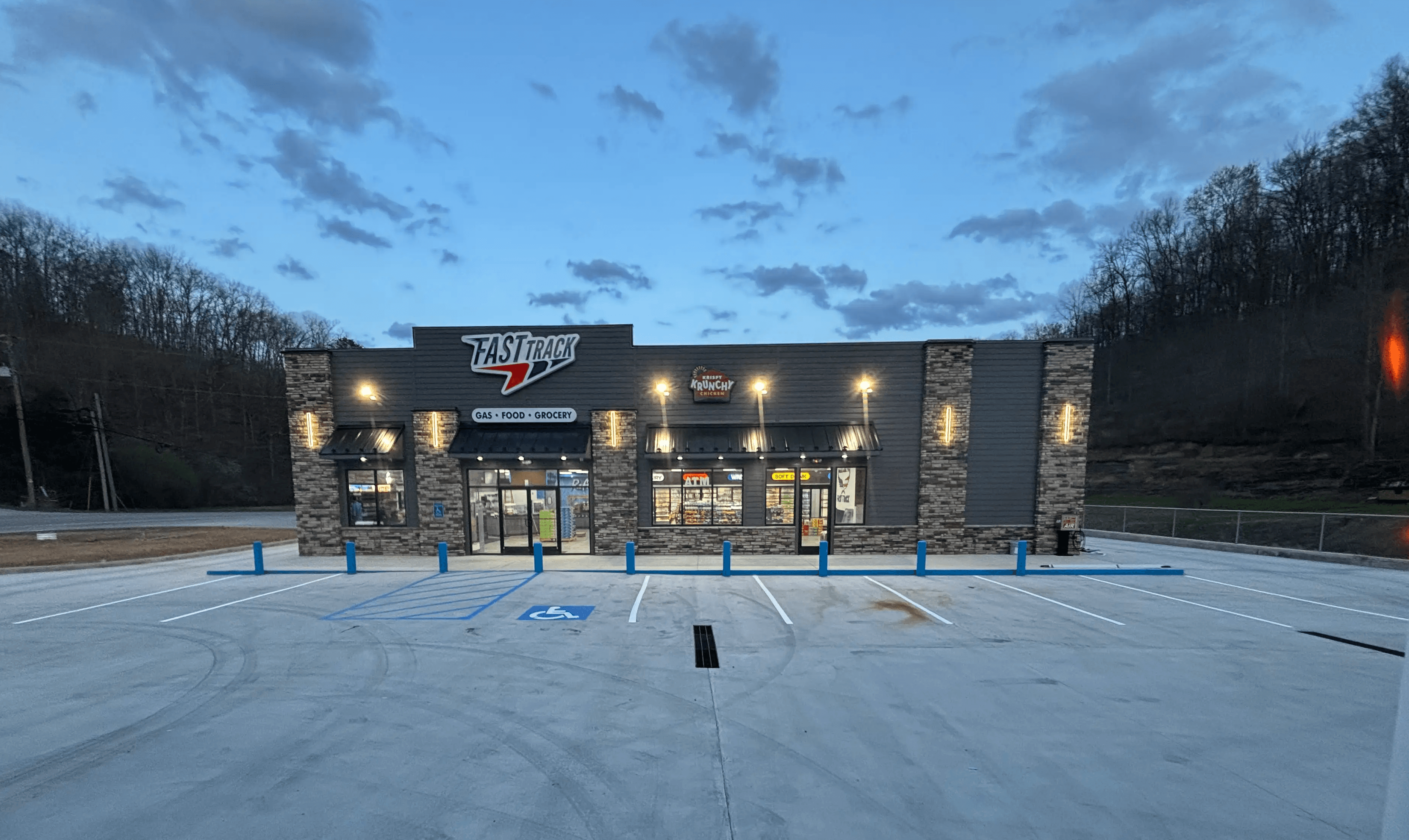 man in orange jacket standing beside yellow truck during daytime