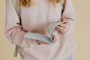 Girl in pink hoodie reading a book
