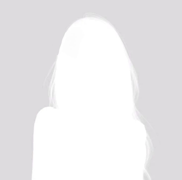 A person with short brown hair looks confidently at the camera, wearing a light pink blazer and white shirt. Soft lighting and plant in the background add a calming tone.