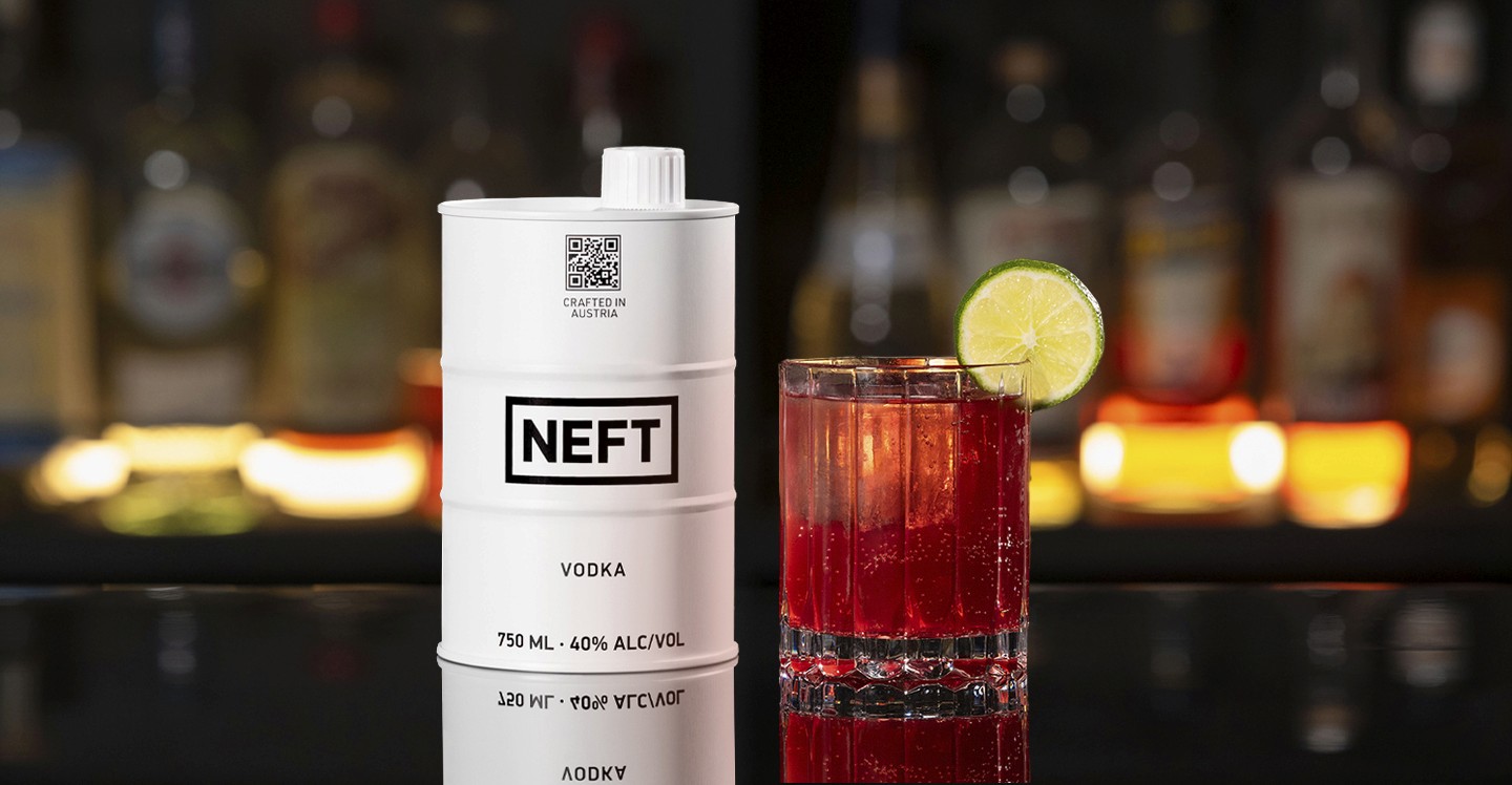 A NEFT Barrel and a glass of Pomegranate Mule on a bar counter.