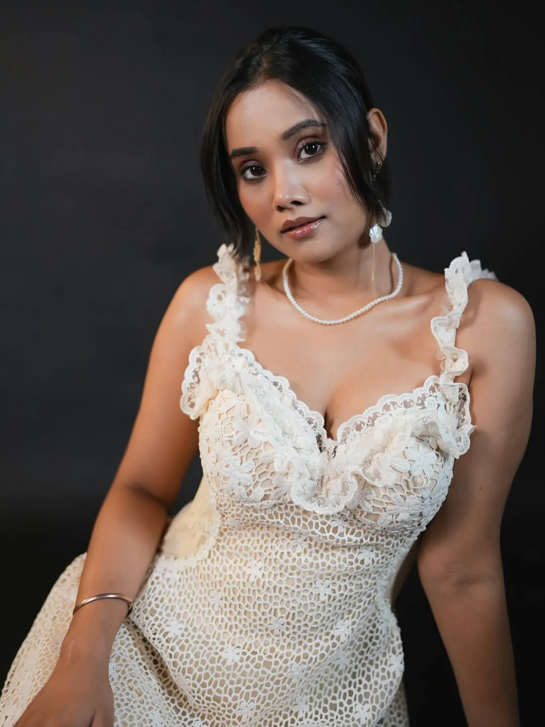 woman looking sideways leaning on white wall