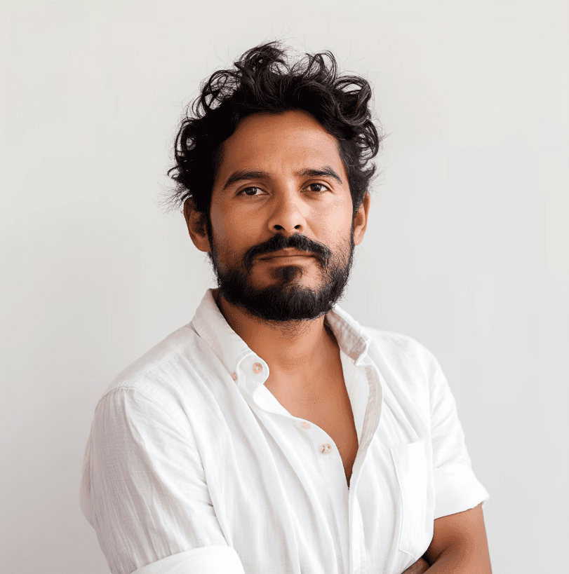  A man with a beard wearing a white shirt, looking directly at the camera with a neutral expression.