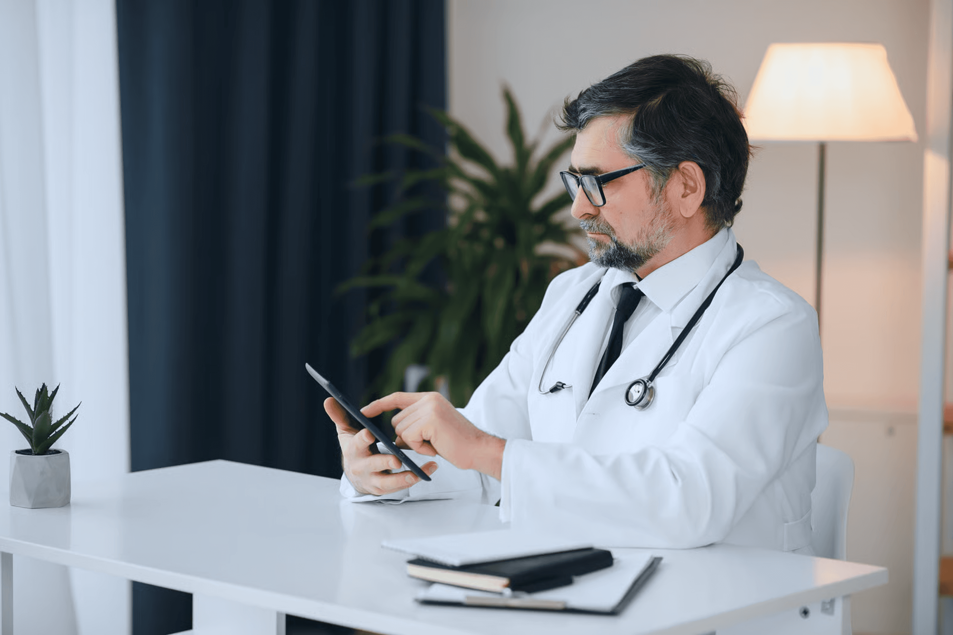 Doctor using a tablet in a clinic, representing secure HIPAA-compliant app development and patient data privacy checklist (2026)