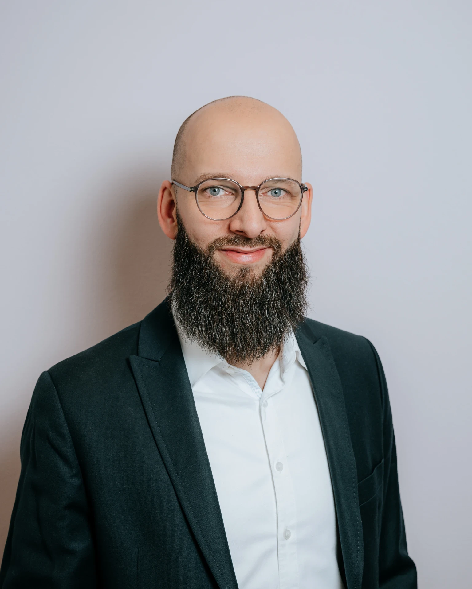Porträt von Daniel De Falco, Geschäftsführer bei baco, mit Brille und Vollbart