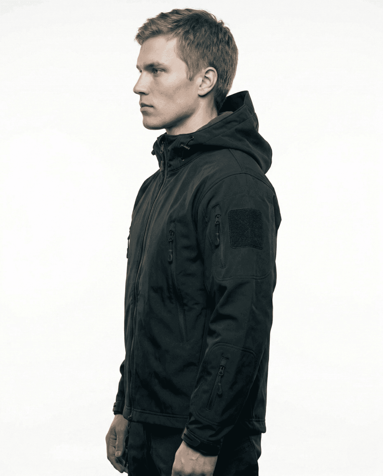 Model wearing black tactical softshell jacket side view