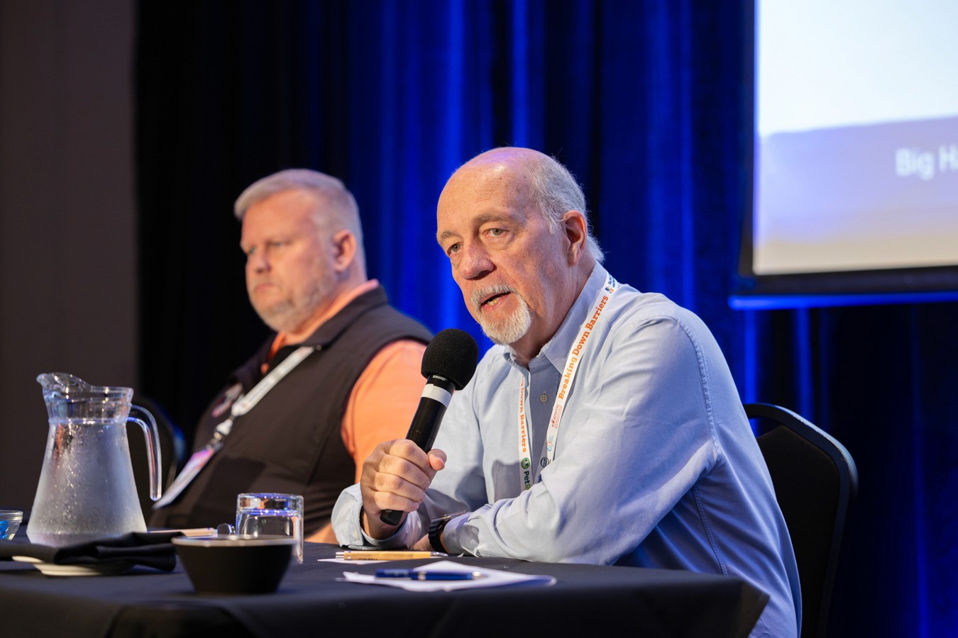 Man speaking into microphone at conference table