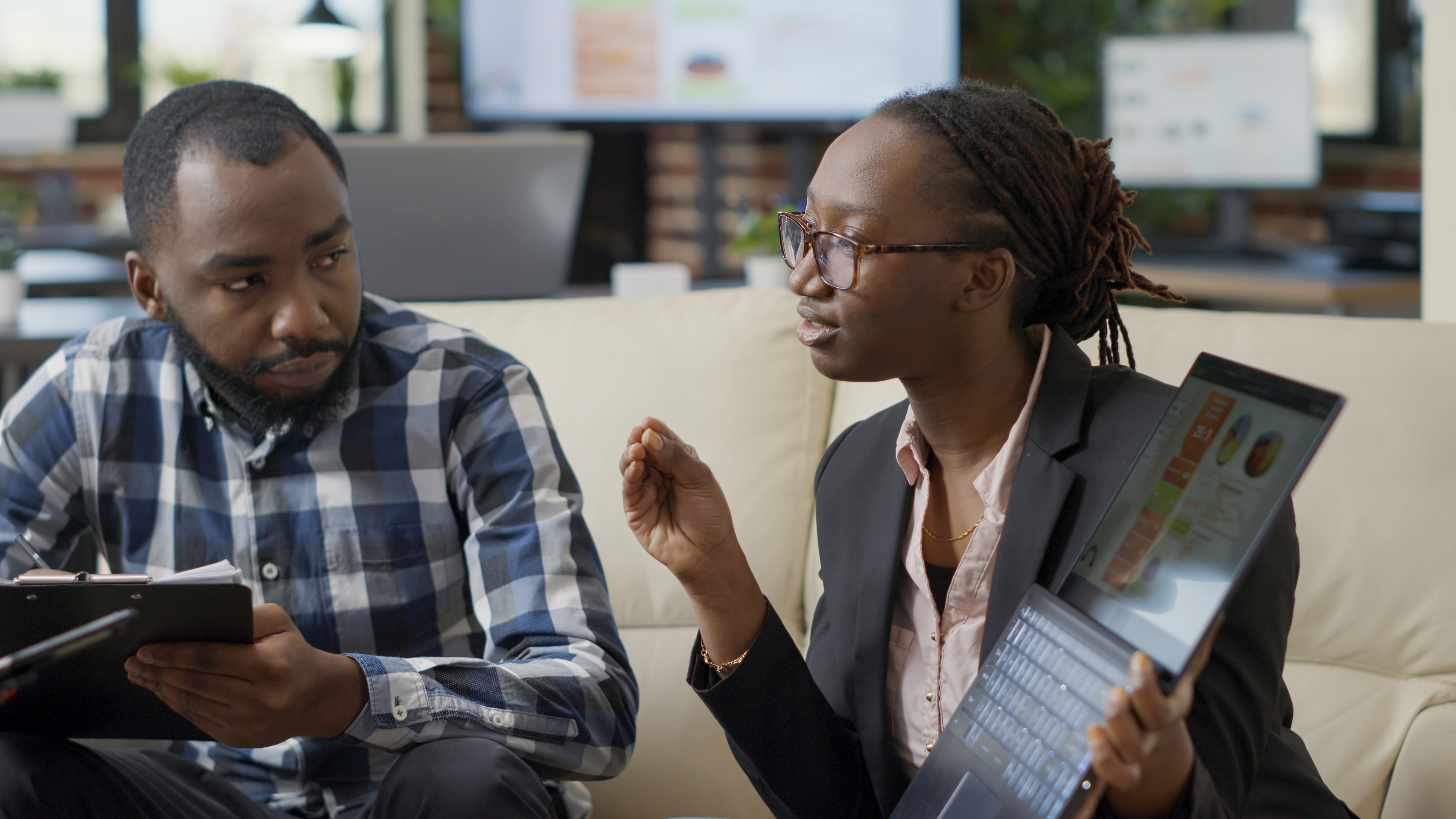 Un homne et une femme noire entrain de collaborer sur un projet professionnel