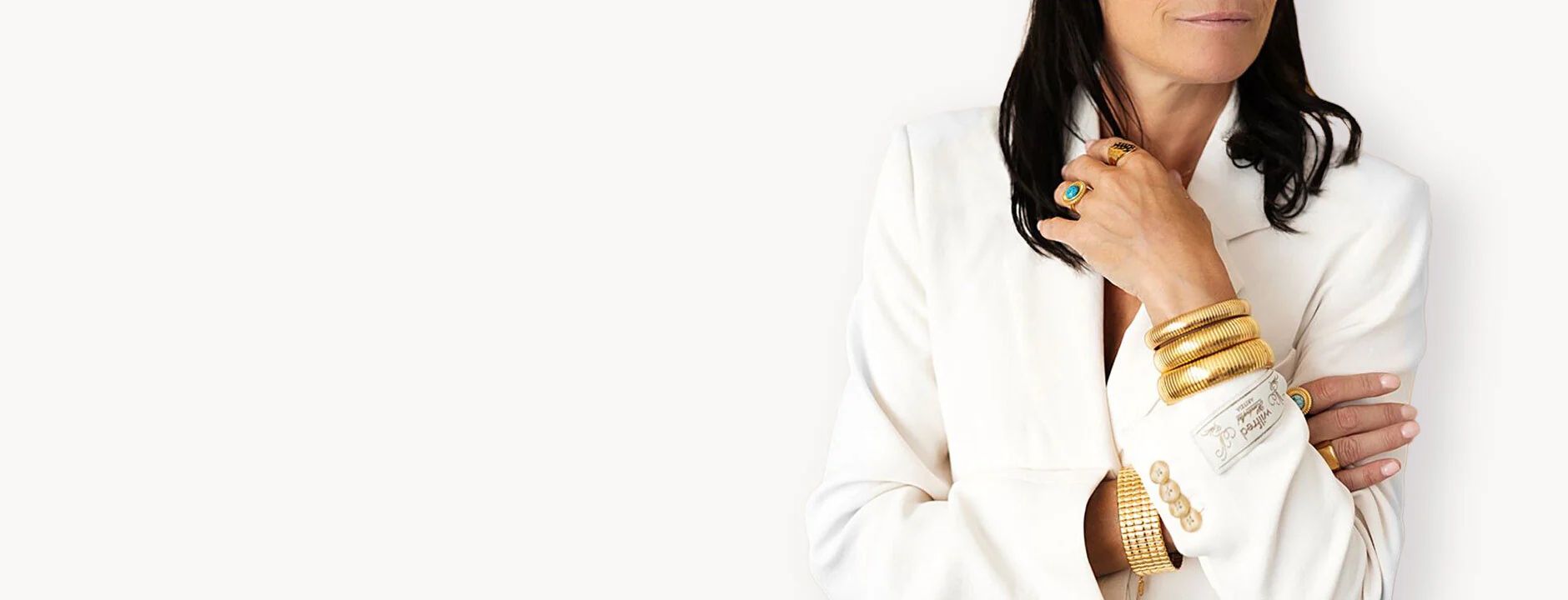 Personne portant une tenue blanche avec des bracelets et des bagues