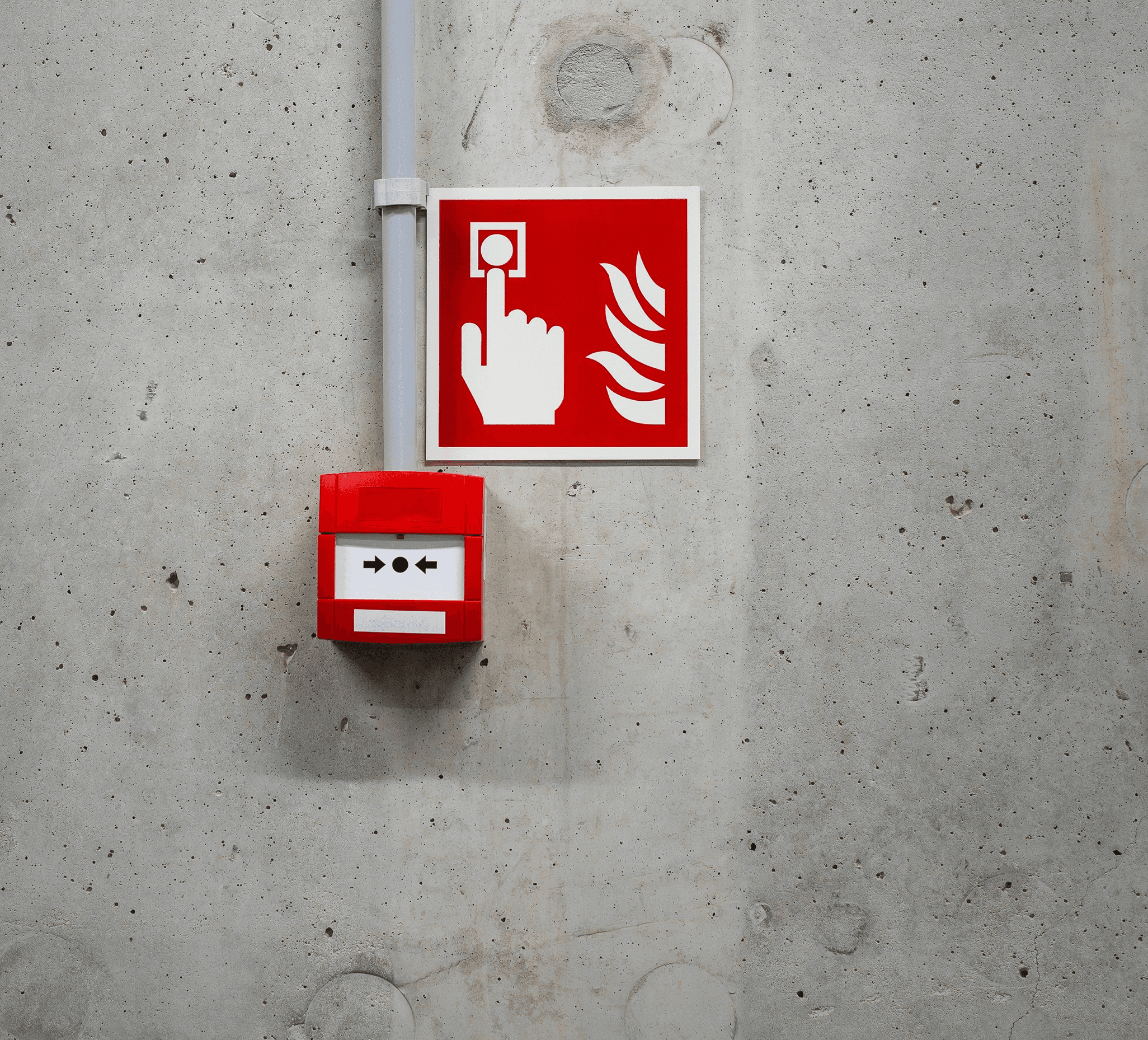A red and white fire extinguisher sign on a concrete wall