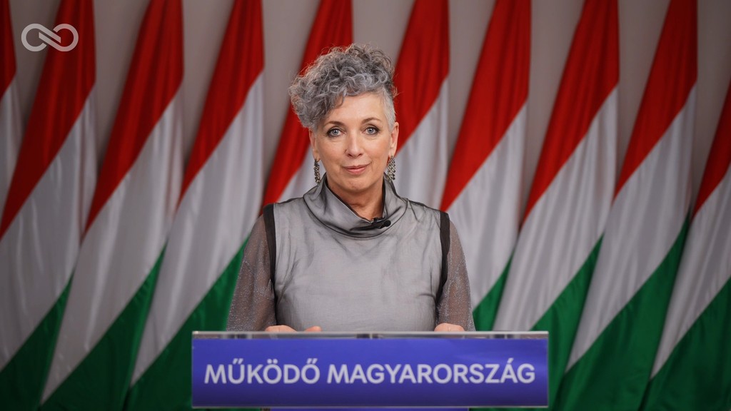 Bódis Kriszta nemzeti színű zászlók előtt