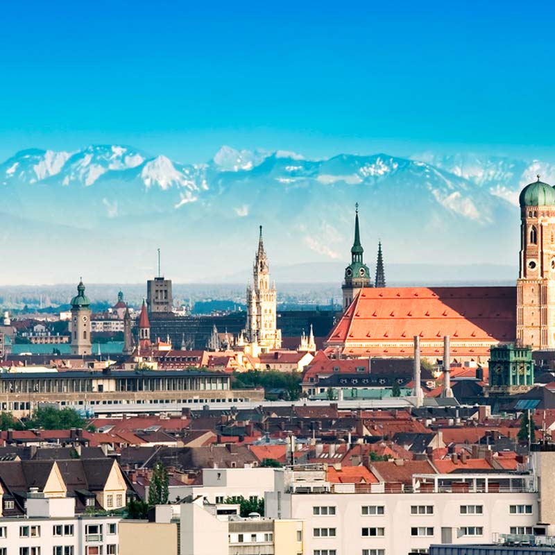 New York City skyline at twilight featuring the Empire State Building and other skyscrapers illuminated against a purple-blue sky.