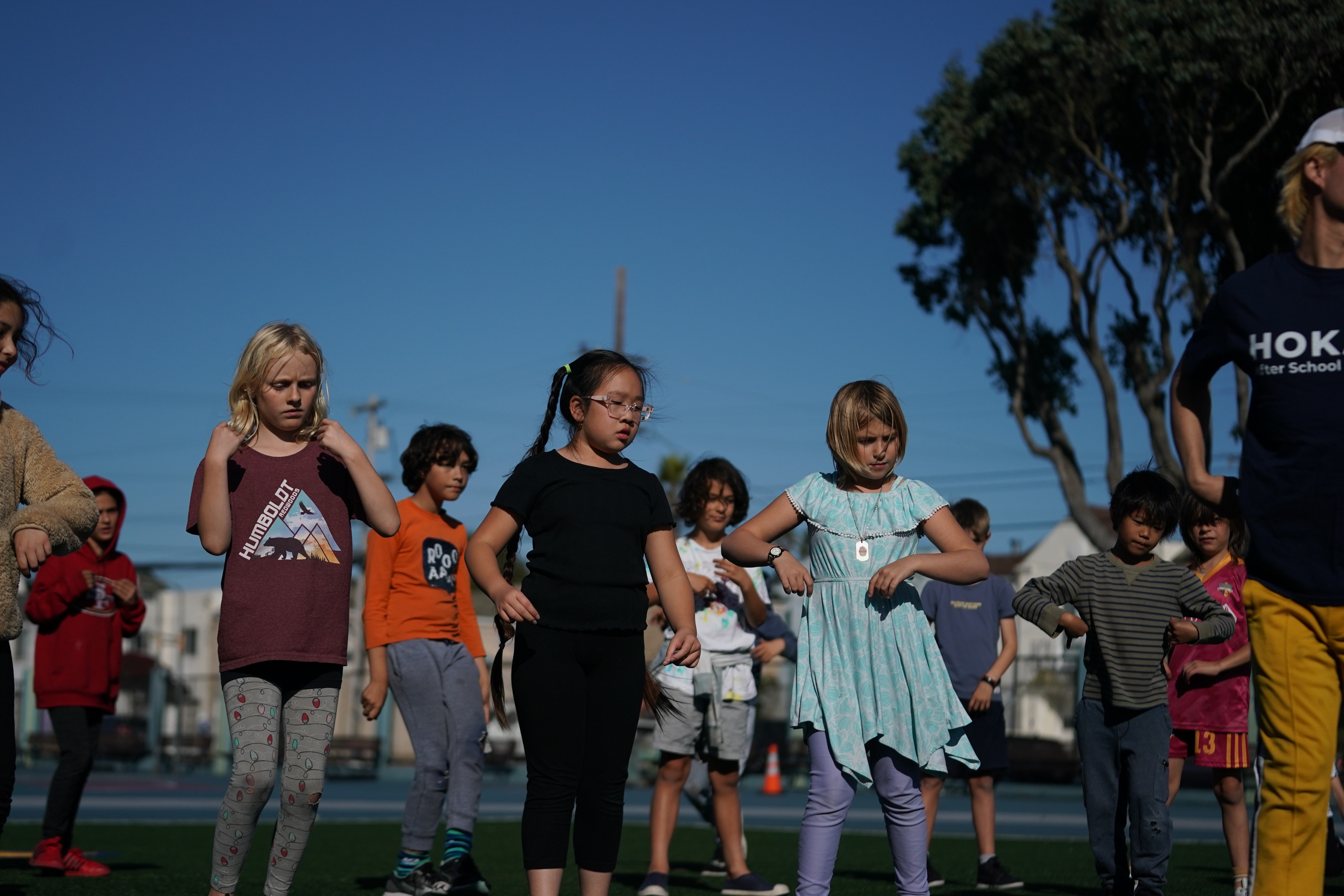 Dance instructor teaching K-pop choreography to students in after school program