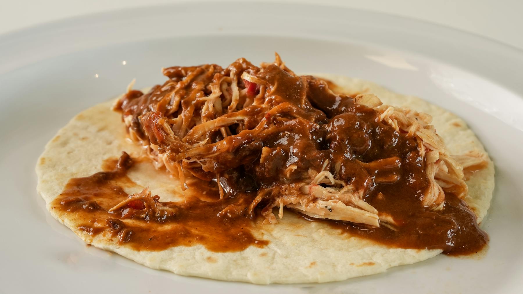 MOLE TACO Tender shredded chicken enveloped in rich, complex mole sauce