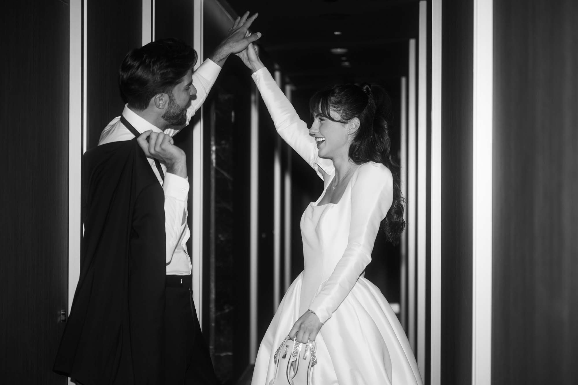 Schwarz-Weiß Bild eines Brautpaares, welches lässig in einem Wiener Hotel steht. 